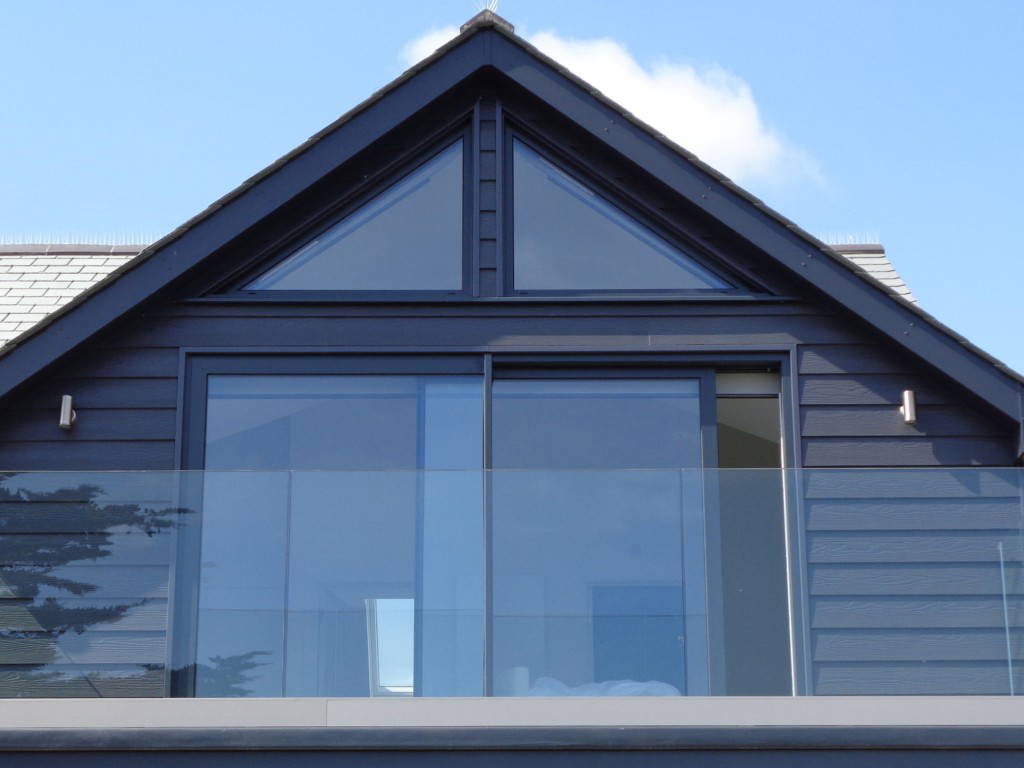 Contemporary new build with grey cladding and large glazing by All Glass Cornwall