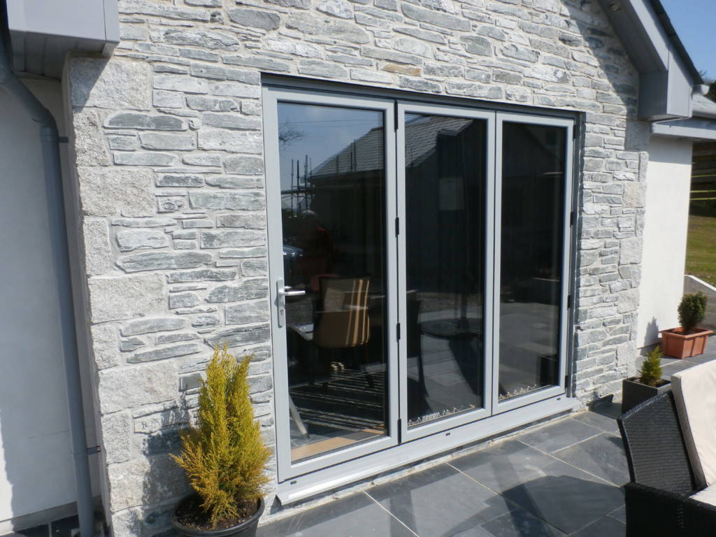 Grey aluminium sliding doors on a stone property – double glazing in Hayle, Cornwall